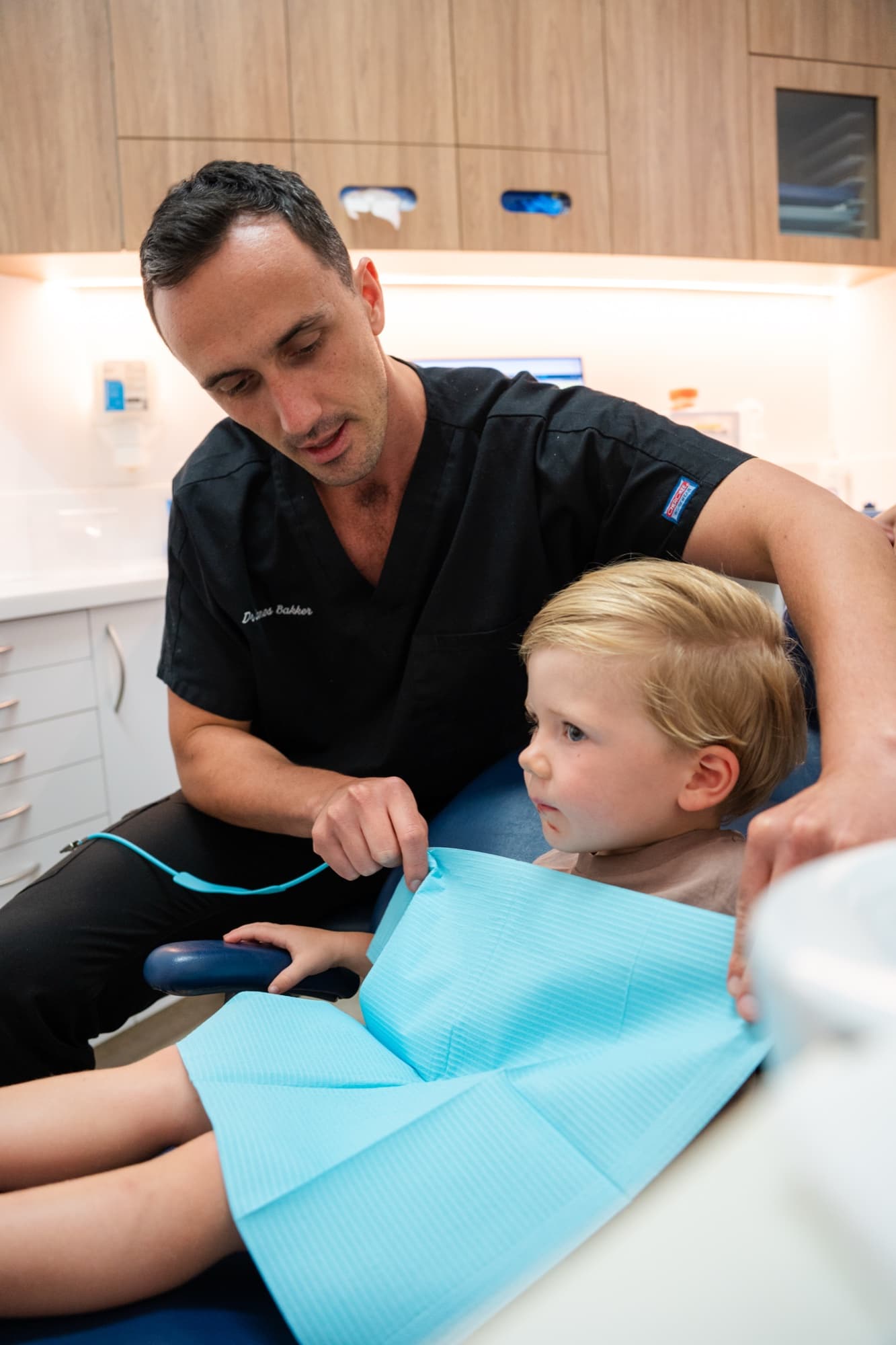 Dr James Bakker placing a bib on a young patient