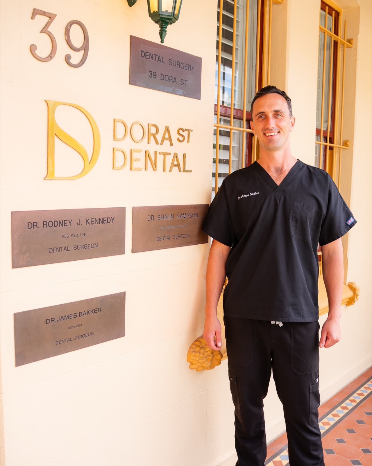 Dr James Bakker beside the DORA ST DENTAL signage at 39 Dora Street, Hurstville